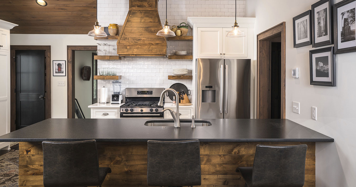 custom kitchen with white subway tile backsplash white cabinetry with black granite countertop and artisan wood finishing