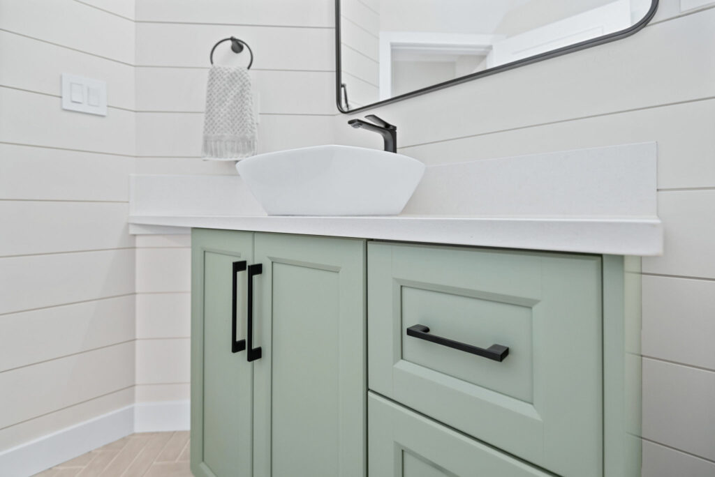 bathoom with mint green cabinets and white shiplap