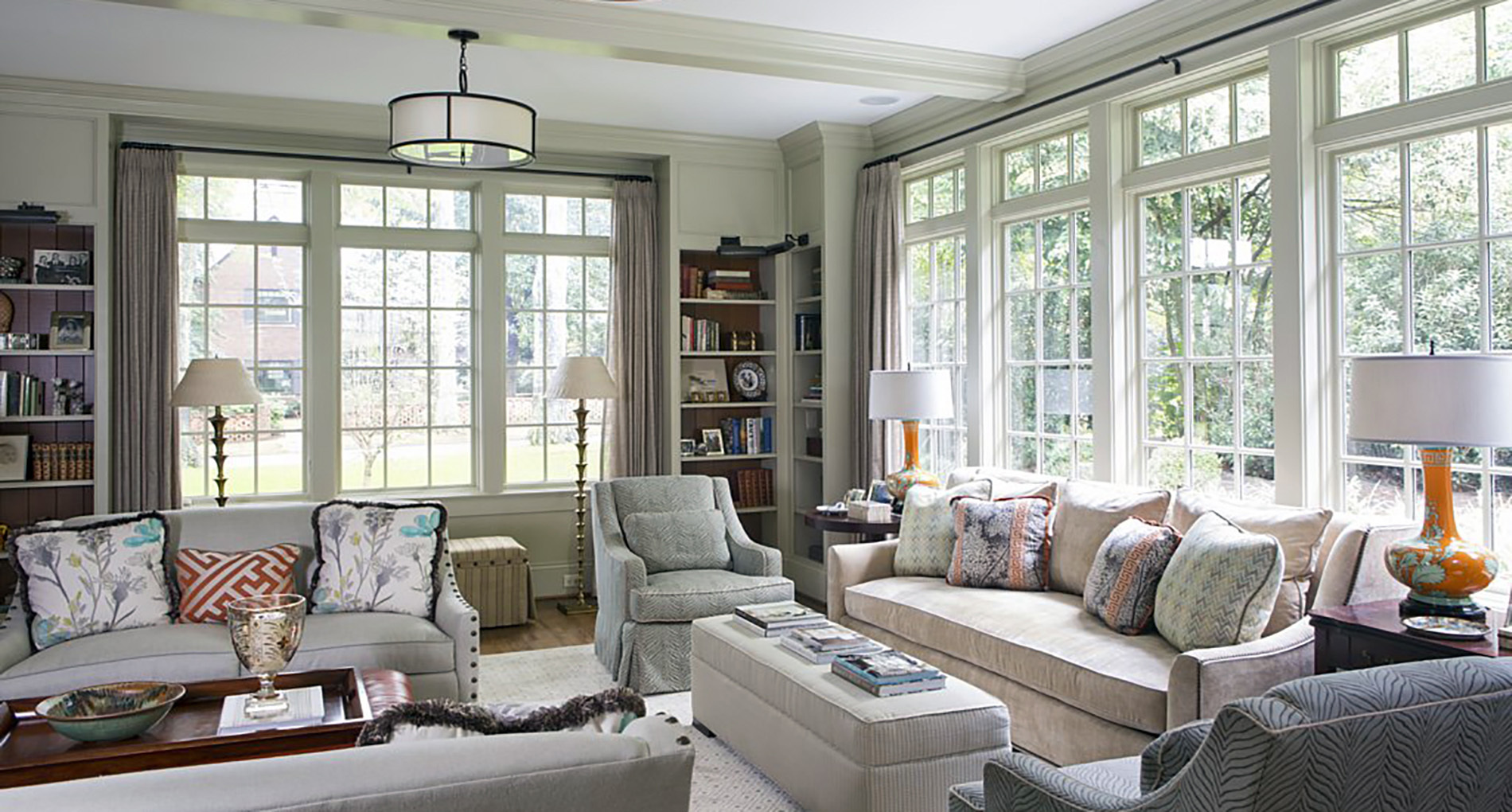 custom neutral colored living room with built in shelving and large windows