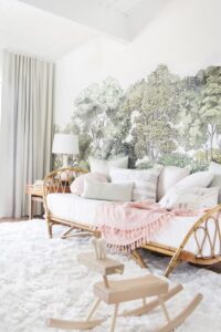 Bold mural themed accent wall behind rattan furniture, giving earthy cottage vibes. 
