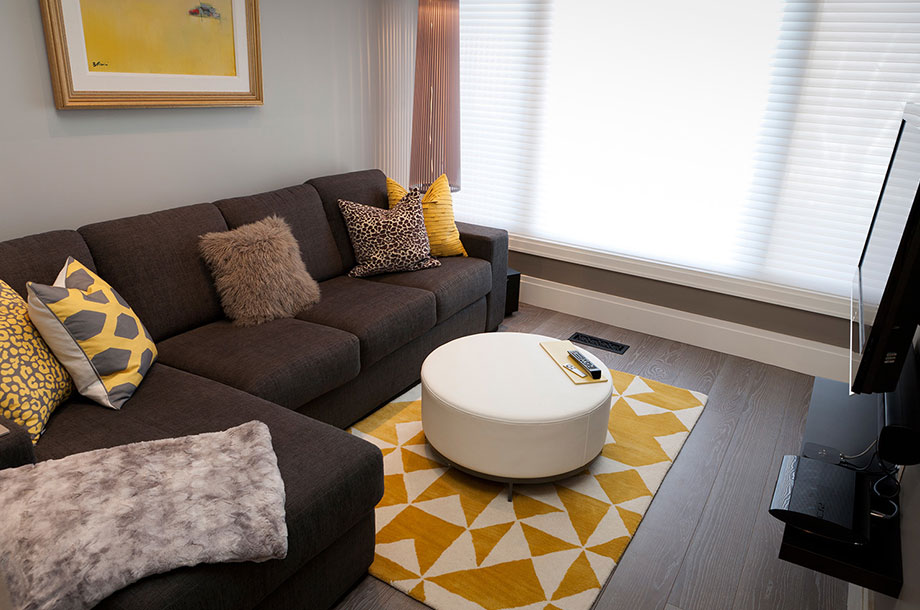 living room with brown sofa with yellow pops of color against dark luxury floor vinyl
