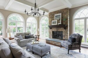 Inviting Loudoun County living room capturing the essence of country, rustic and traditional design. Light brown brick framesthe fireplace, adding a rustic warmth to the space. Stylish grey couches offer a modern touch while seamlessly blending the traditional country elements.