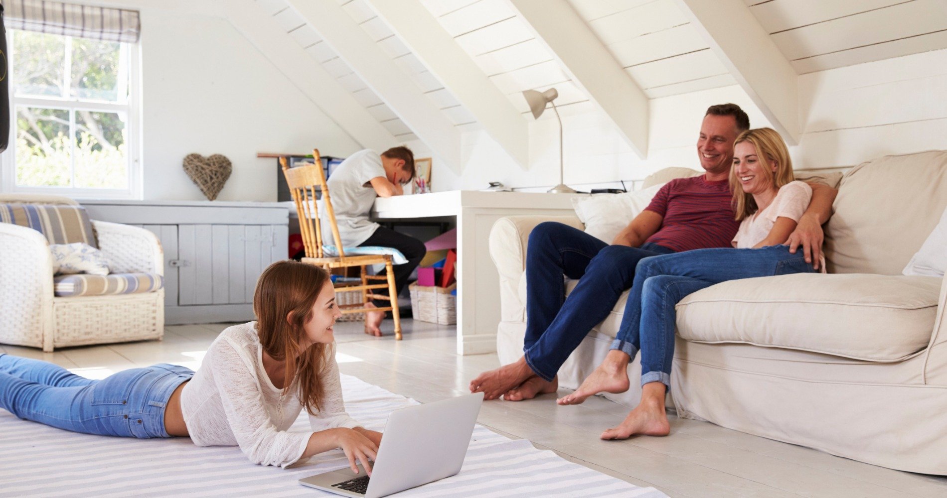 Child studying near family in the living room