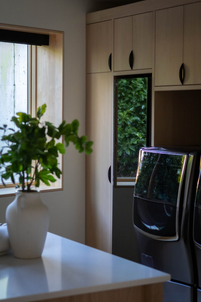 custom cabinetry and an island is a great laundry room design idea that we incorporated in a custom home on Lake Washington
