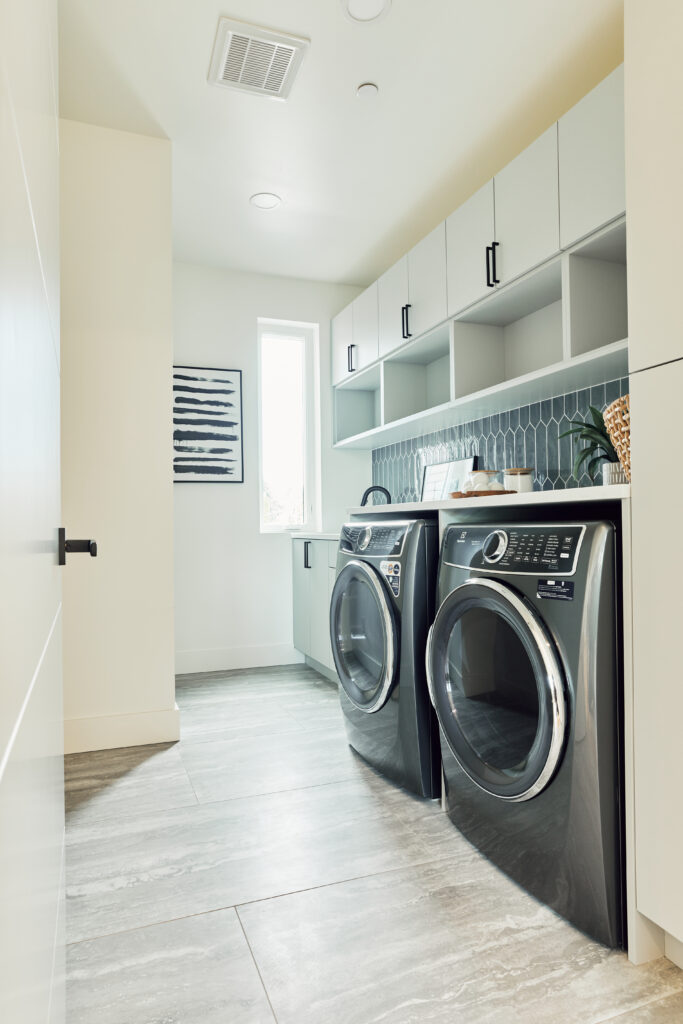 a spacious laundry room with both front loading washer and a dryer in a custom home on Lake Washington | Alair Homes Kirkland