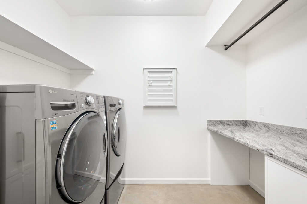 a custom laundry room with a great countertop space, open shelving and a drying rod | Alair Homes Kirkland 