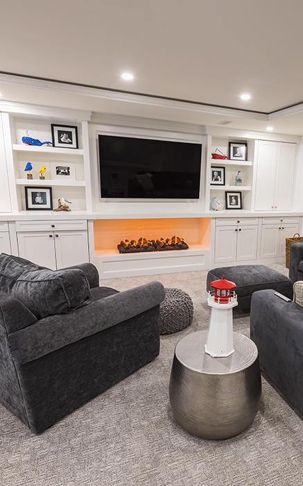 custom entertainment space with two lounge chairs around fireplace and tv