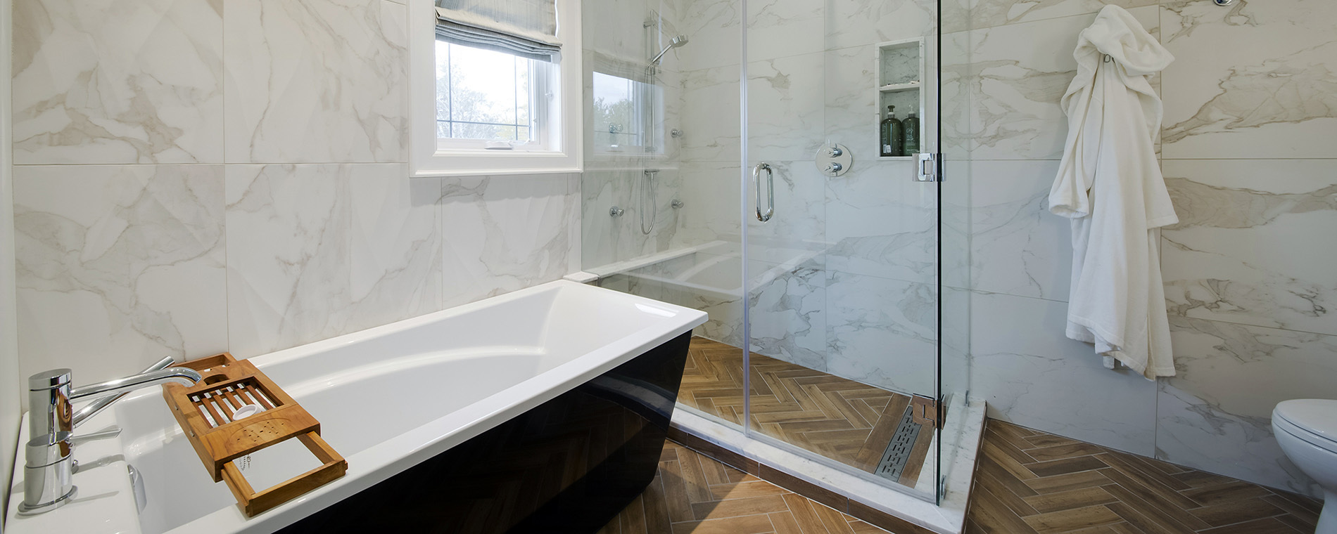 master bathroom with wood flooring and black destination tub