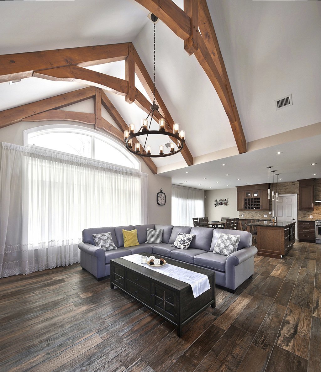 Custom Collingwood living space with high ceiling and large lighting fixture over grey sofa