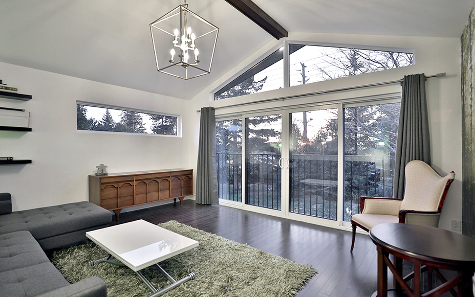 midcentury modern designed sitting area custom lighting fixture large sliding glass doors acting as windows and entrance to porch