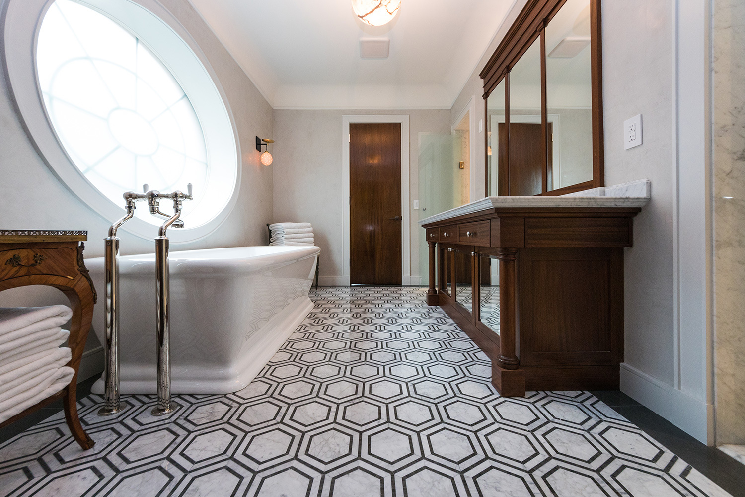 spa style bathroom with destination tub and hexagon patterned tile