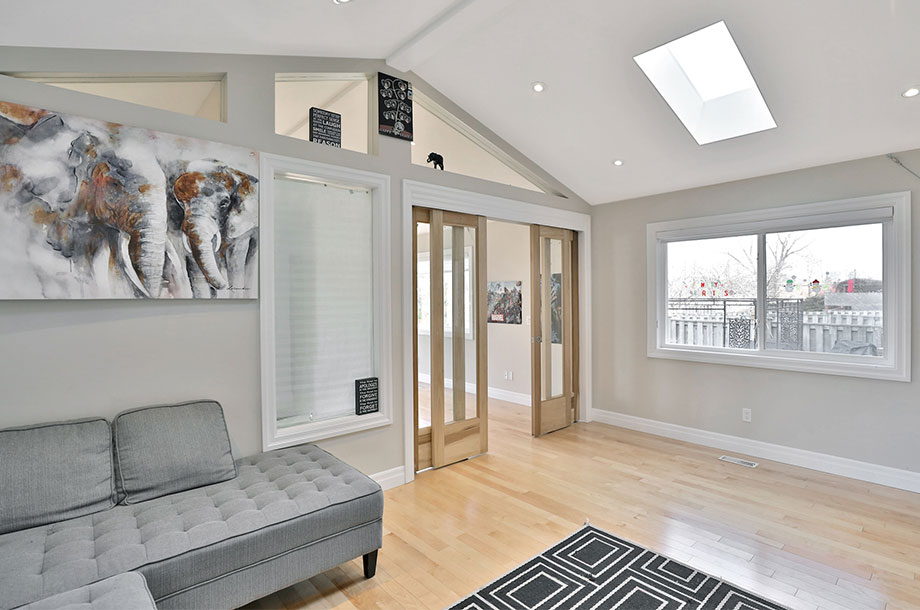 living area with L-shaped grey sofa and small skylight