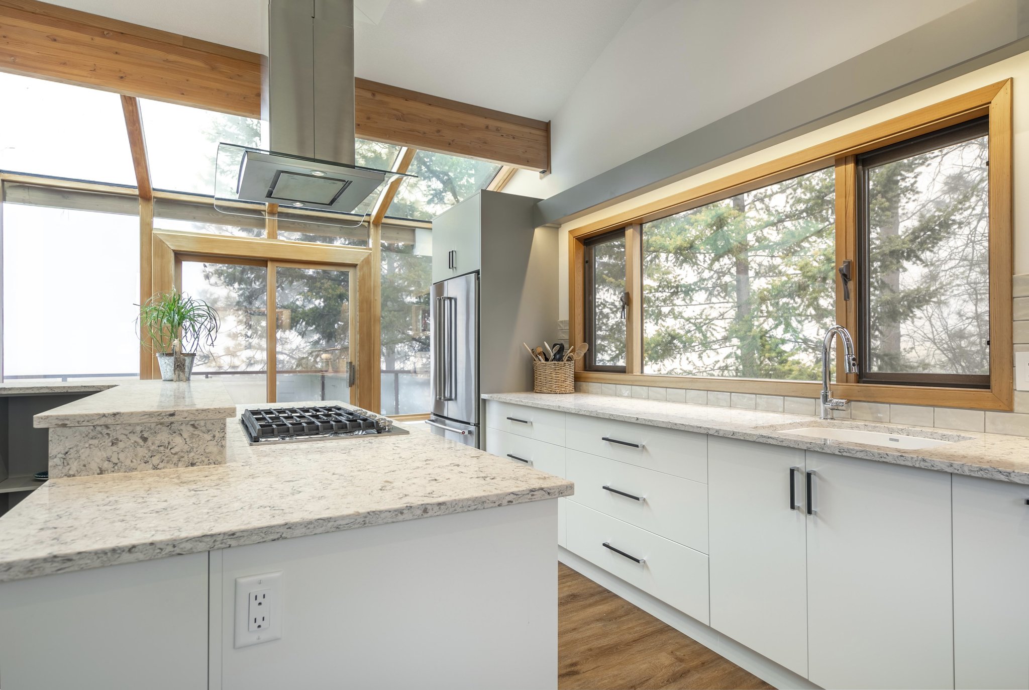 Kitchen all white cabinetry and large windows all over 