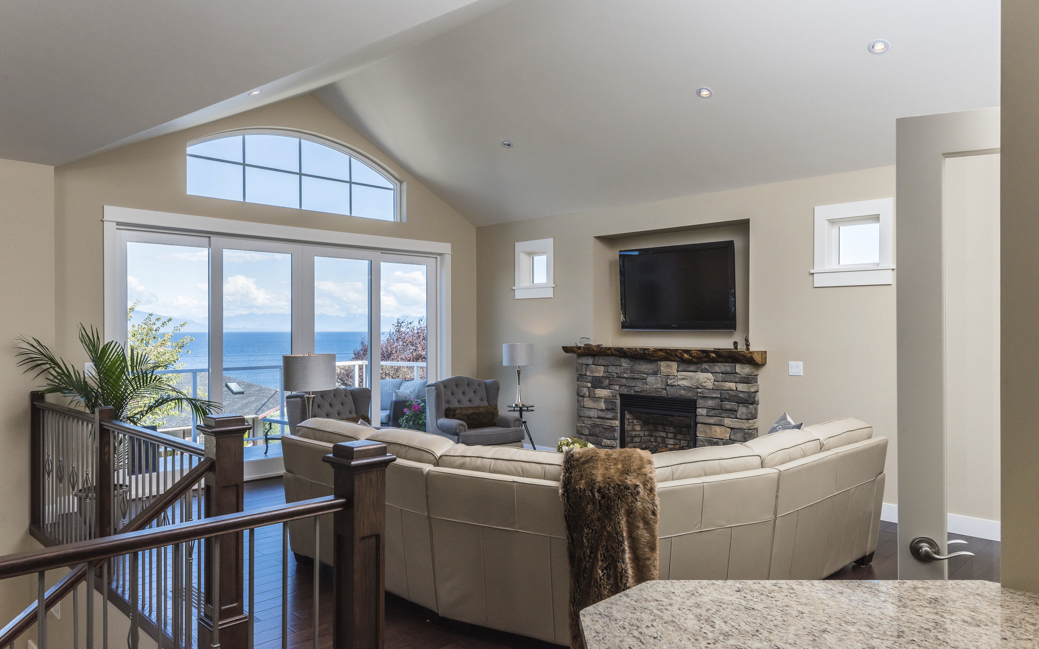 isolated living area with L-shaped couch around fireplace and mounted tv and exit to porch