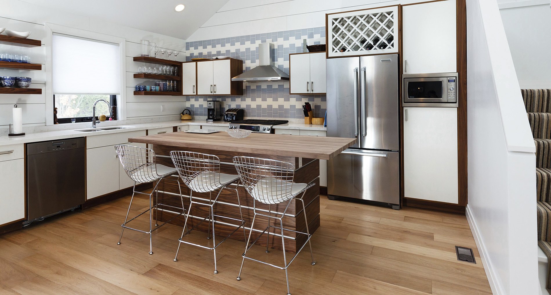 custom white kitchen with wooden accents and stylish blue and white tile backsplash 