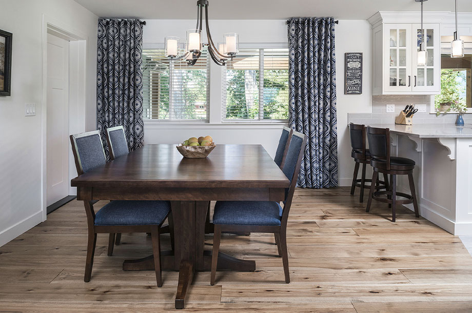 dining area with dark wood table with navy accents and natural looking vinyl wood flooring 