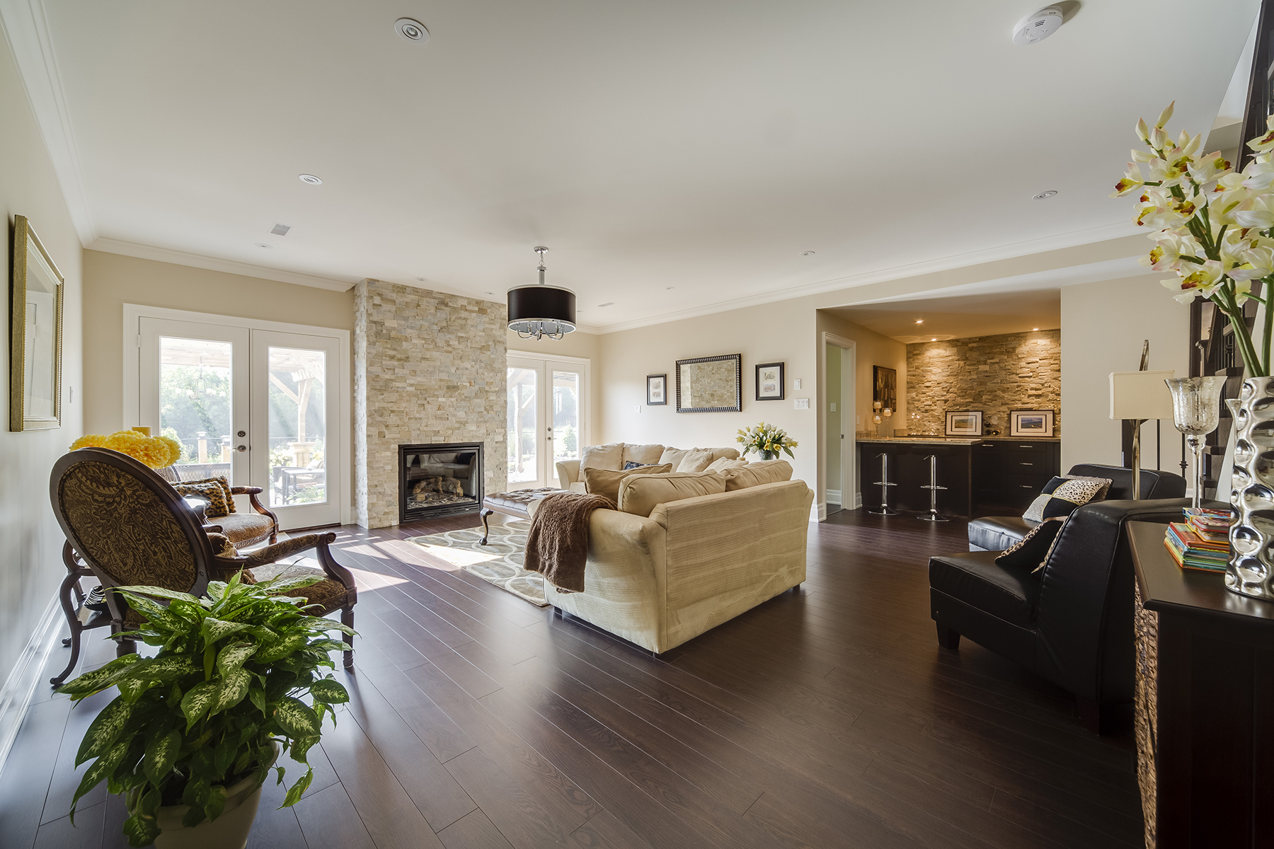 naturally lit sitting area with sofa and chairs around fireplace