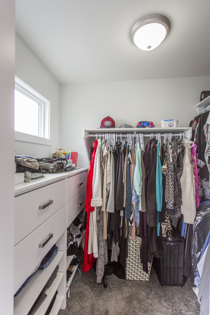 closet with wall of built in drawers and extra shelving