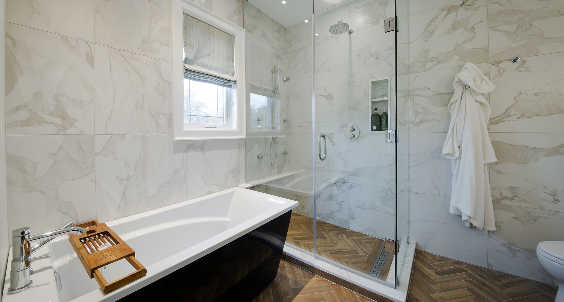 custom bathroom with patterned wood flooring and white marble shower
