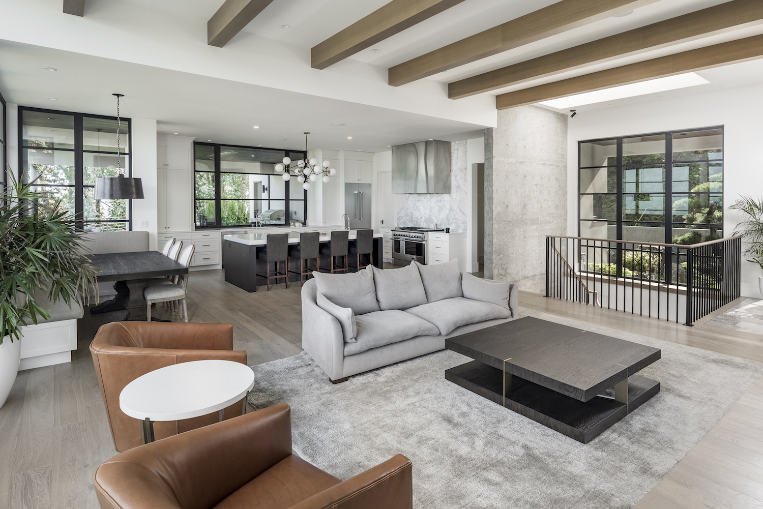 interior of open concept custom home with vaulted ceiling leather sofa chairs and grey sofa 
