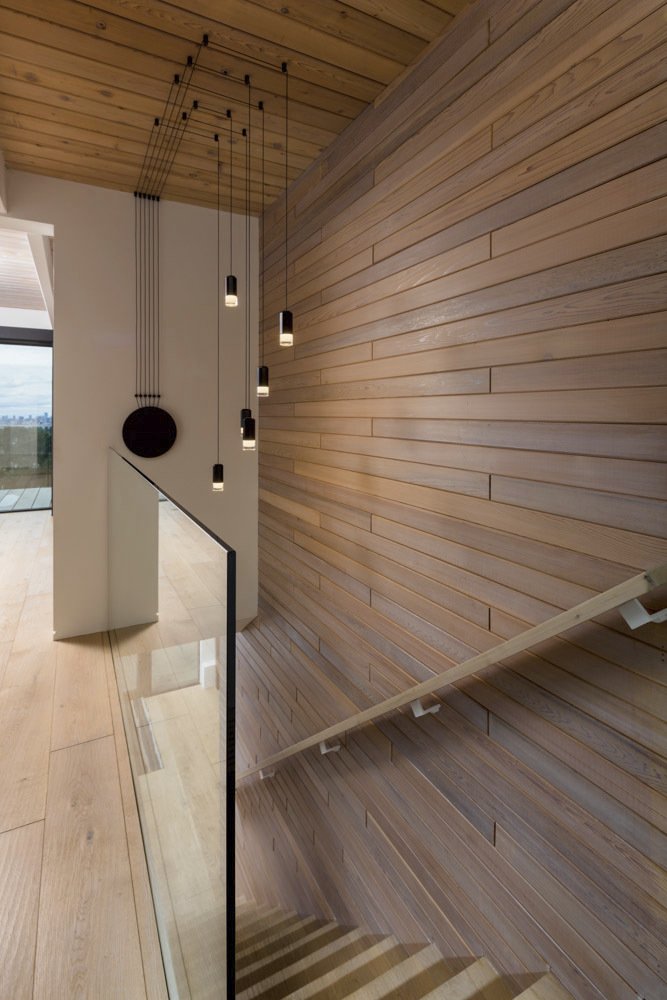 Custom staircase with wood paneling and hanging lights