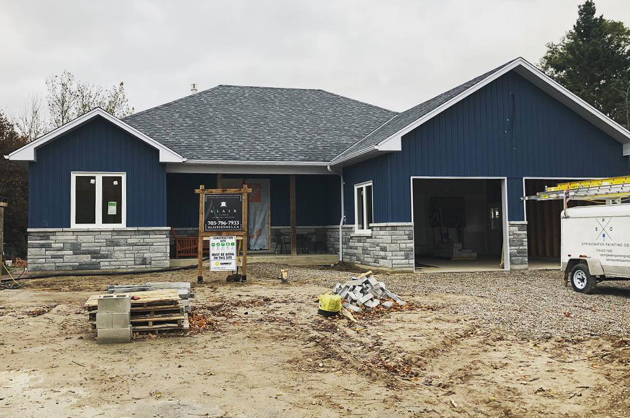 Custom home with navy vertical vinyl siding and custom masonry