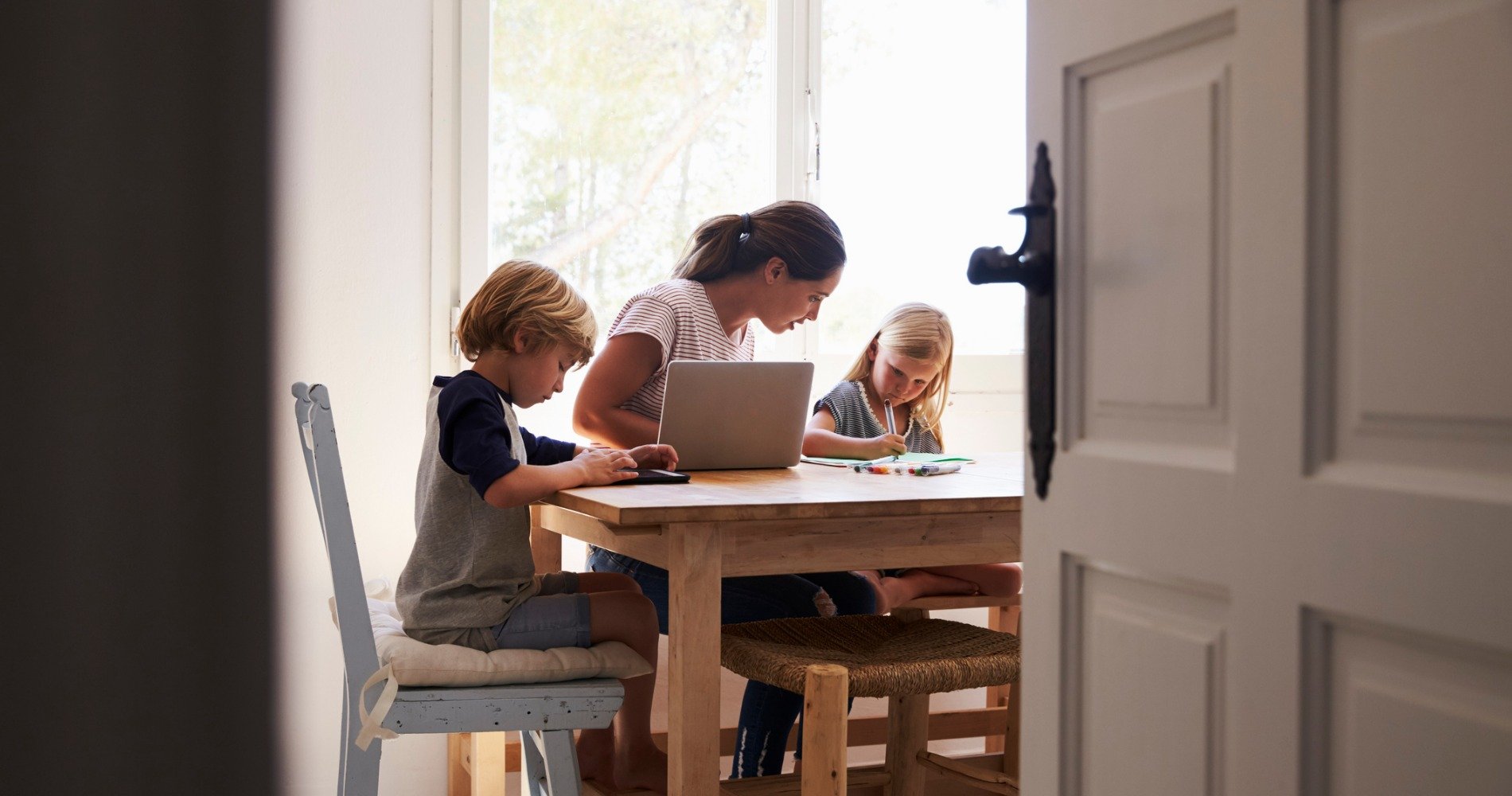 Family working on homework together at a kitchen table