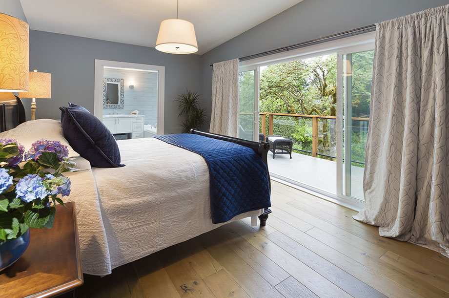 guest room with small patio light colored walls and wood floor