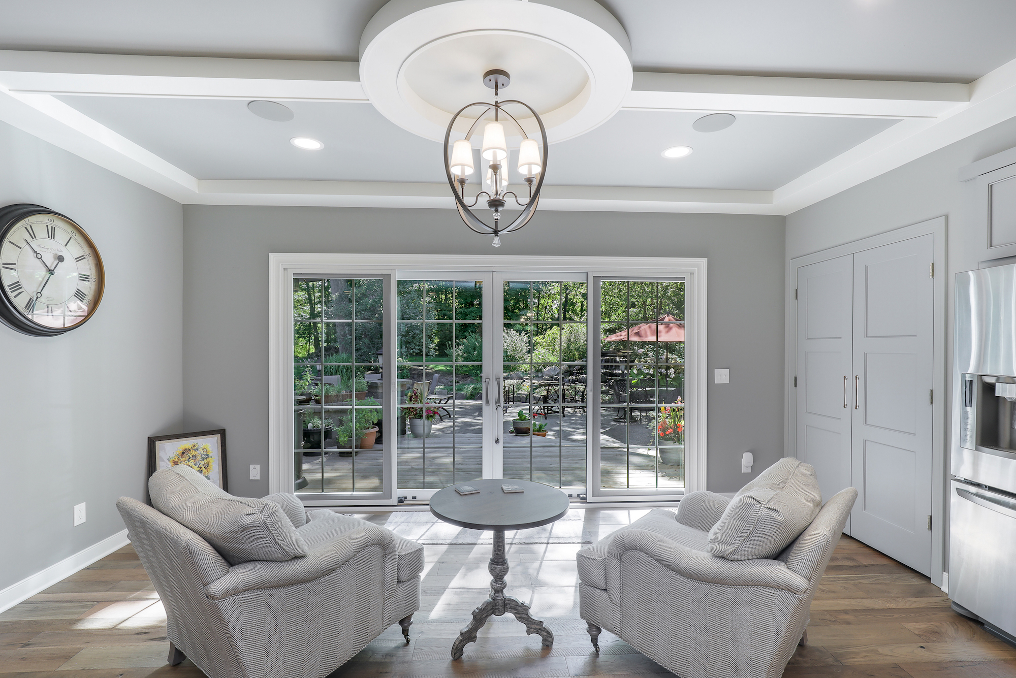 sitting area of custom home with chairs facing outdoor area custom lighting fixture above