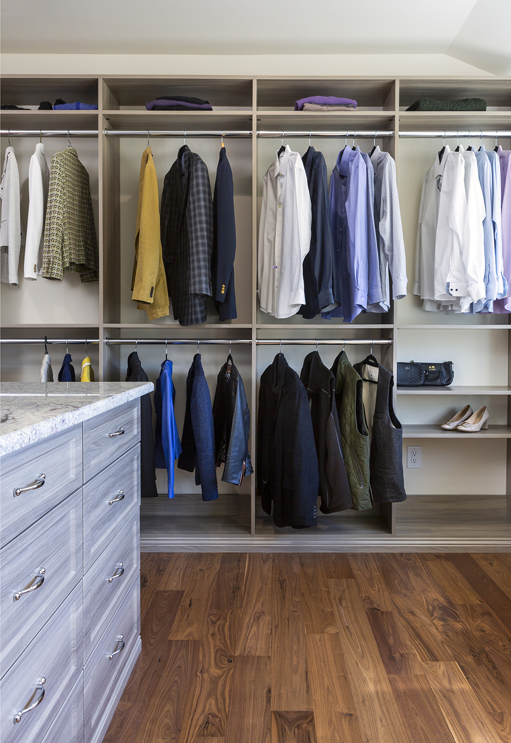 organized closet with island and mixed stain wood finishings