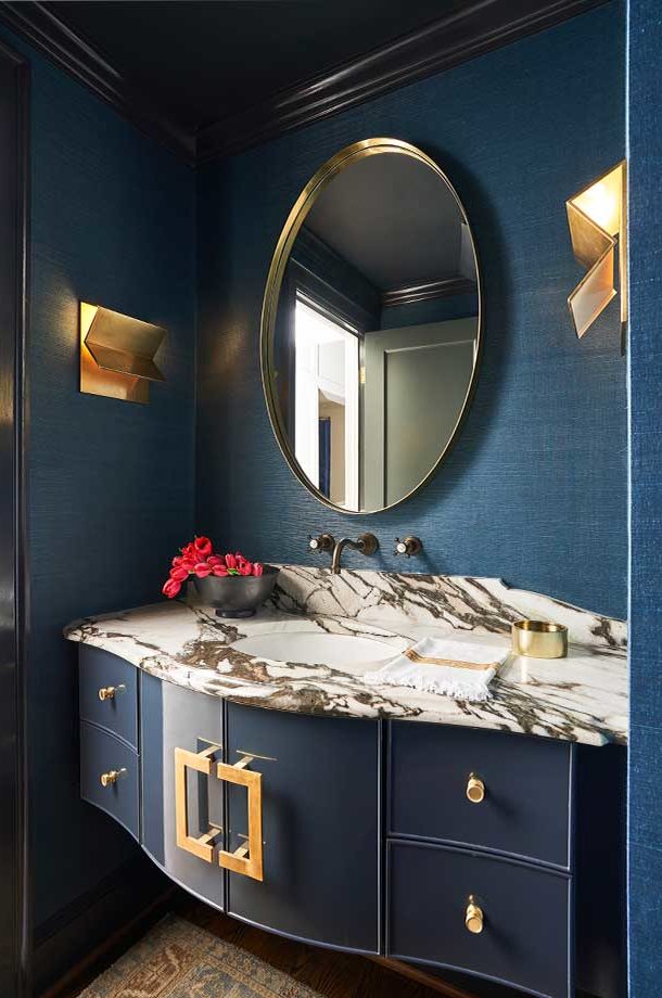 deep blue vanity gold finish circle mirror black and white marble countertop built in wall sconce