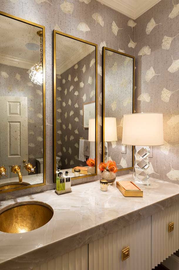 custom light grey neutral toned bathroom with three gold rimmed rectangular mirrors and gold sink