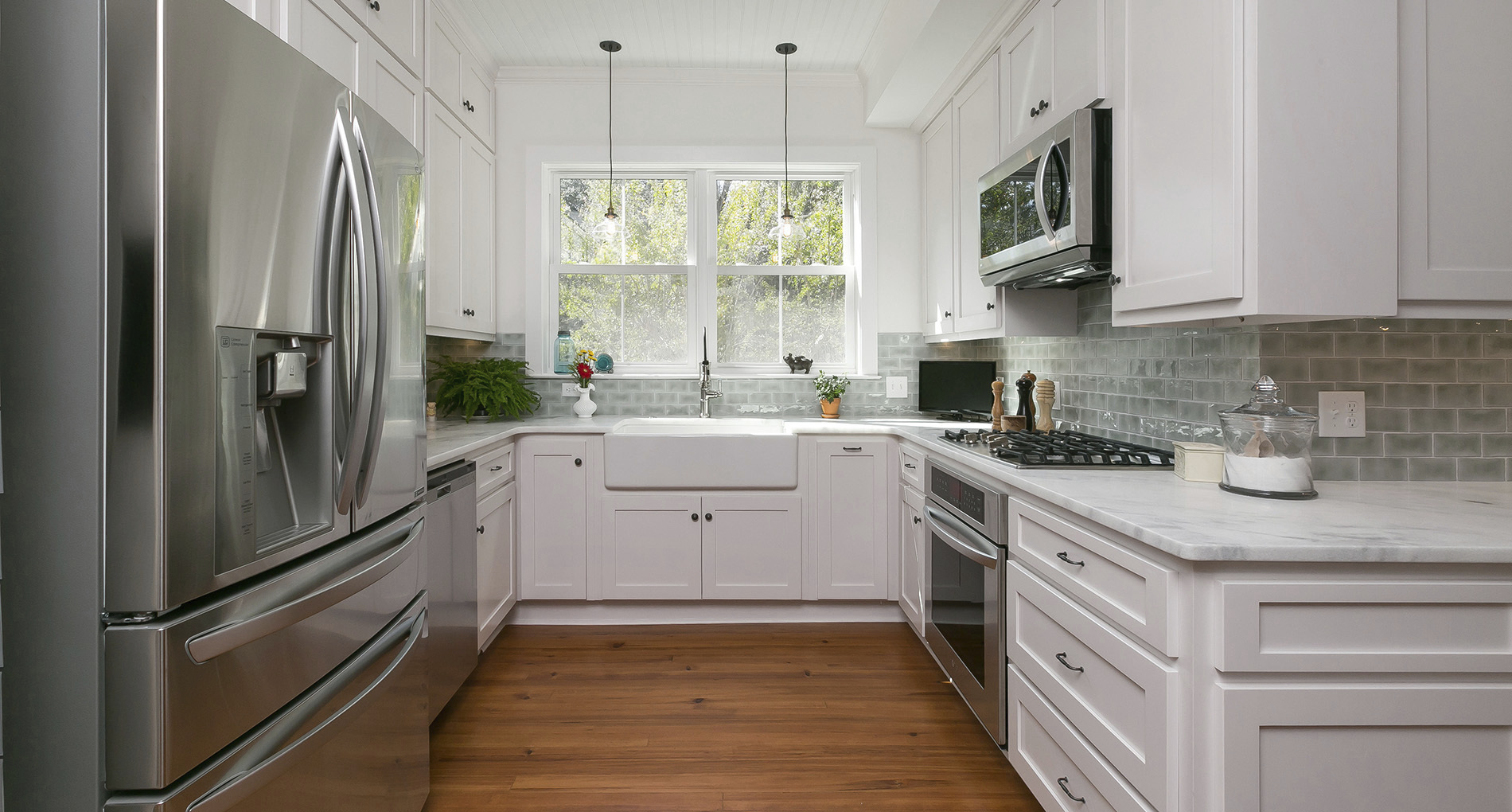 Custom kitchen with trough sink, mint backsplash and white cabinets