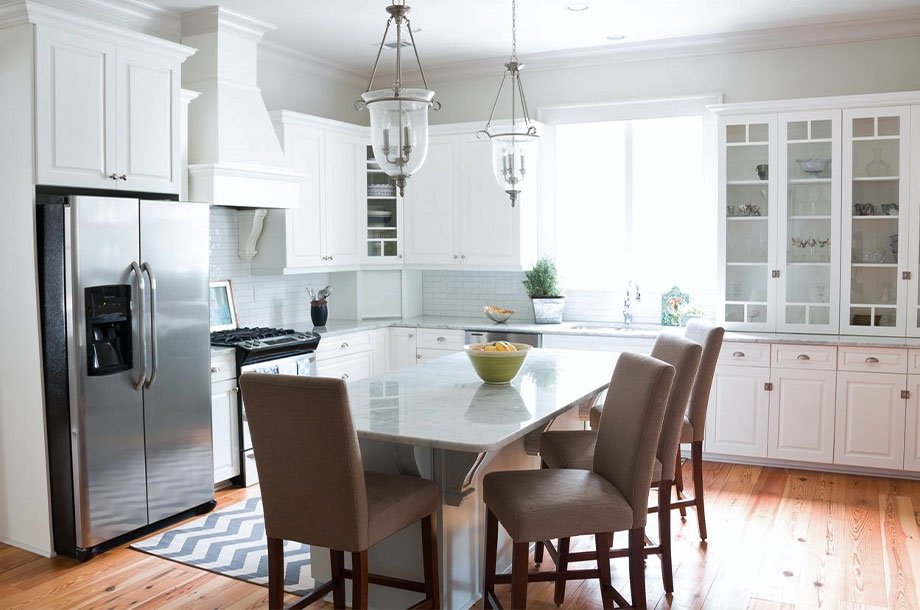 brightly colored custom kitchen with cherry floors and small window letting in natural light