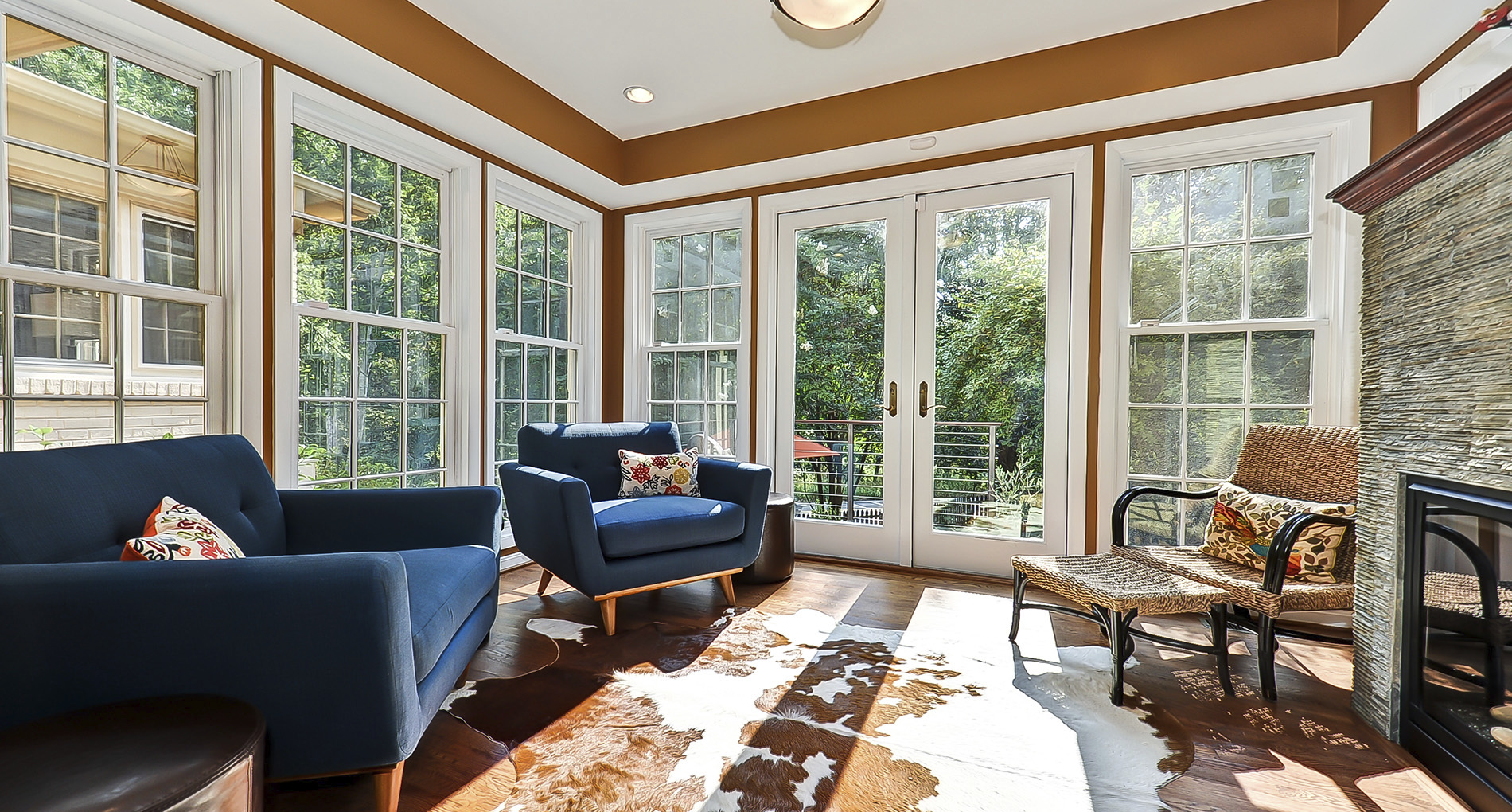 enclosed sun room with animal hide rug blue chairs