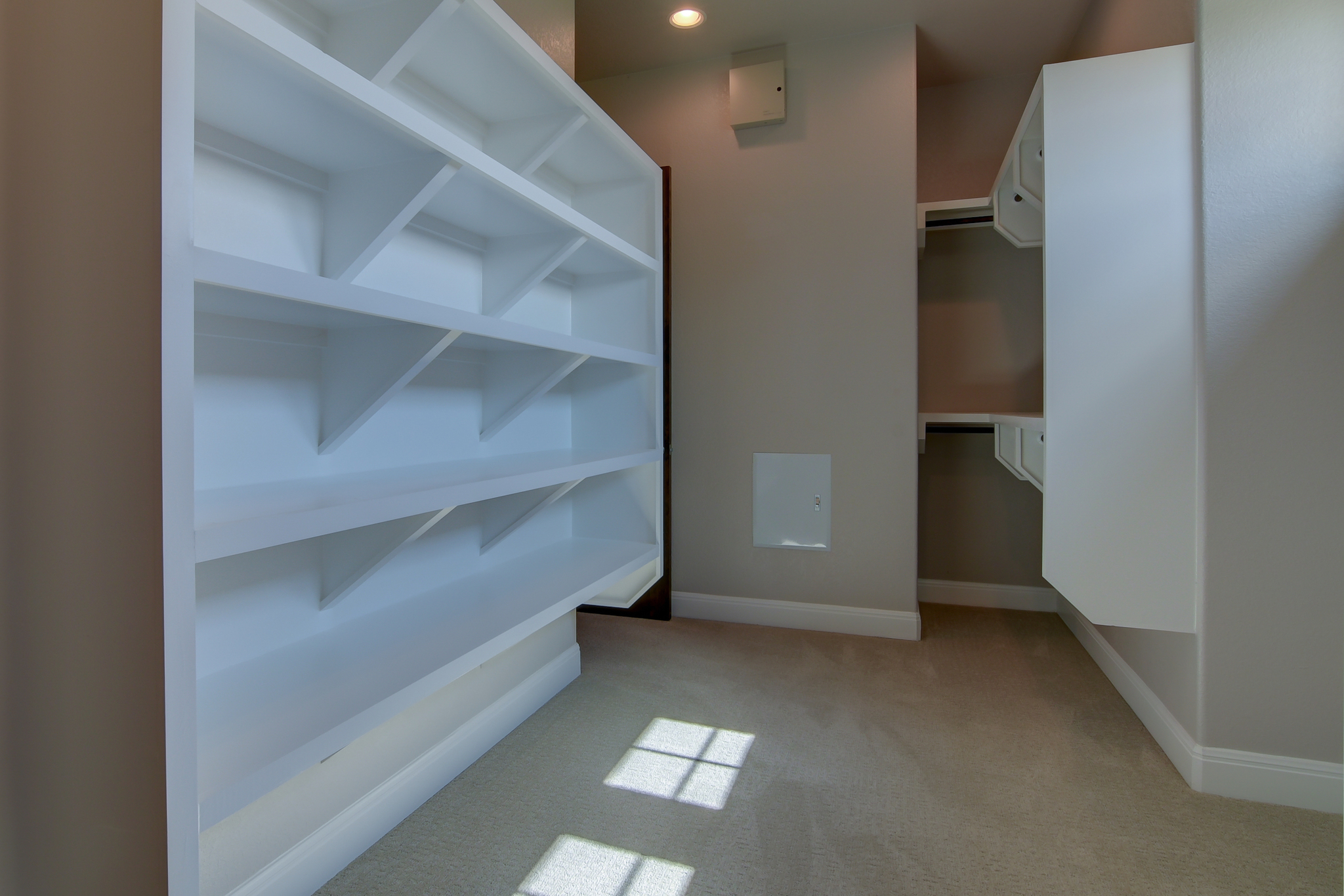 walk in closet with multi-level built in shelving units