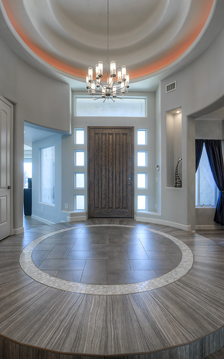 circular entrance with lighting fixture over large wood door 