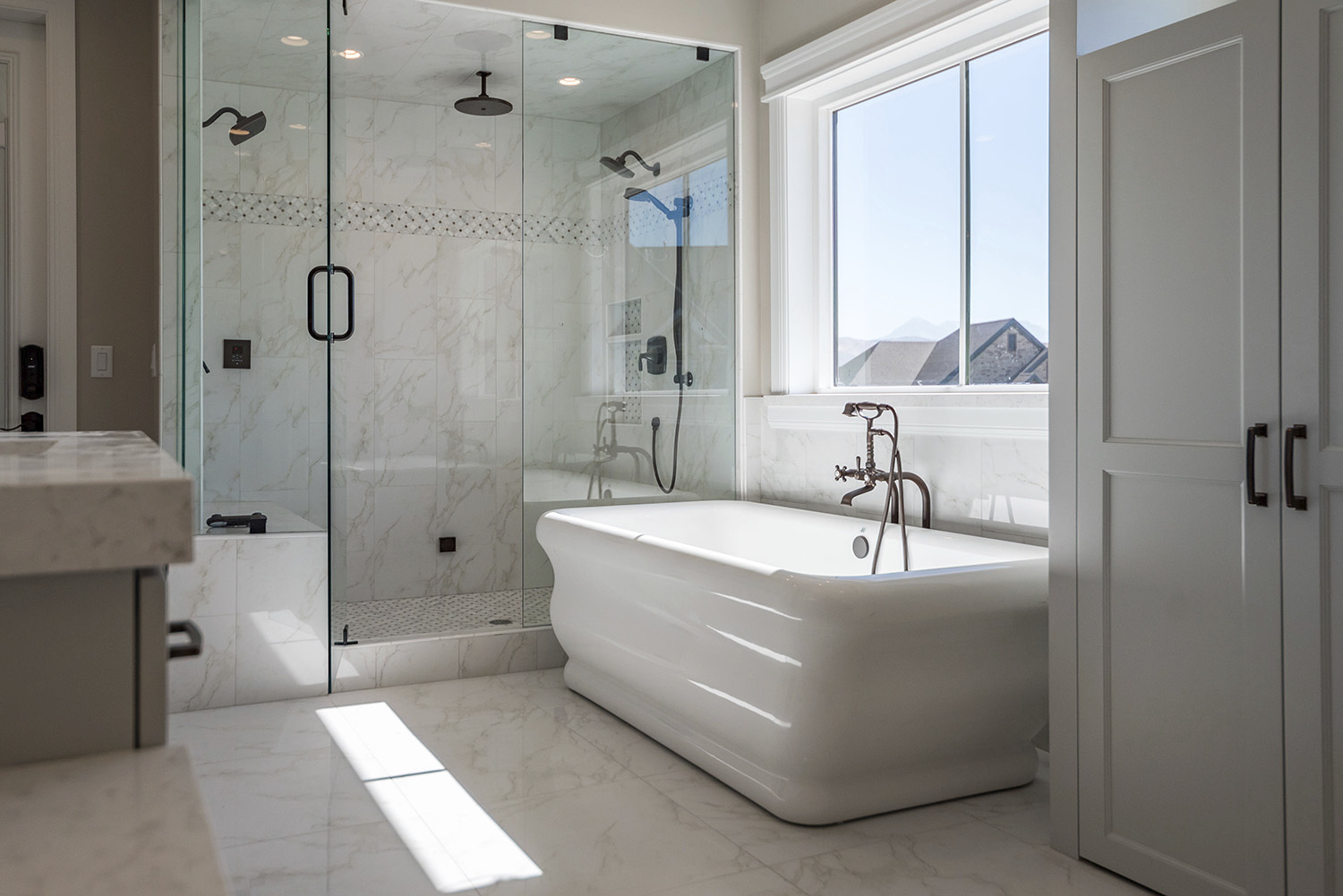 Custom bathroom with white marble tile rainfall shower and a destination bath tub