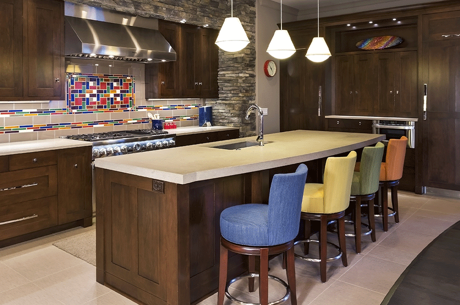 custom kitchen with colorful bar chairs and hanging lights over rectangular island